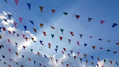 慢运动色彩斑斓的设计装饰三角公平旗帜吹风挂蓝色的天空背景有趣的节日聚会，派对事件盛宴庆祝活动假期狂欢节节日事件